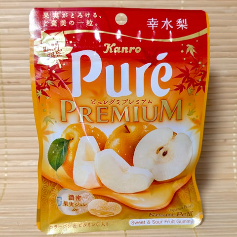 A warm orange autumn 54g pouch of Kanro Puré Premium Kosui Pear gummies displaying sliced Asian pears on a bamboo mat background.