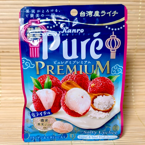 A deep blue and pink sea-themed pouch of Kanro Pure Premium Salty Lychee gummy candy showing fresh fruit and sea salt graphics on a tatami background.