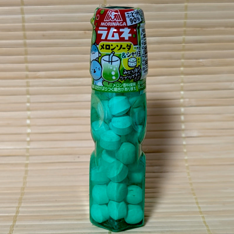 A plastic pack of Morinaga Melon Soda Ramune compressed sugar pellets from Japan. Displayed on a tatami background.