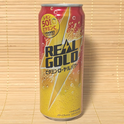 A bright yellow and red 500ml tall can of Coca-Cola Real Gold Energy Soda with a bolt design on a bamboo background.