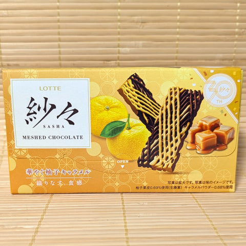 A box of Lotte Sasha meshed chocolate with yuzu citrus and caramel flavoring. Displayed on a wooden surface