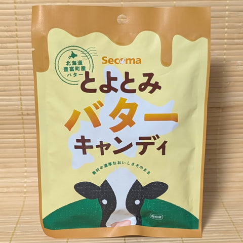 Seicomart Secoma Butter candy package with a cow illustration it displayed on a wooden surface.