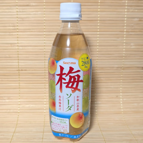 A 500ml bottle of Seicoma Ume Plum Soda with a light amber liquid and prominent Japanese text on a tatami background.