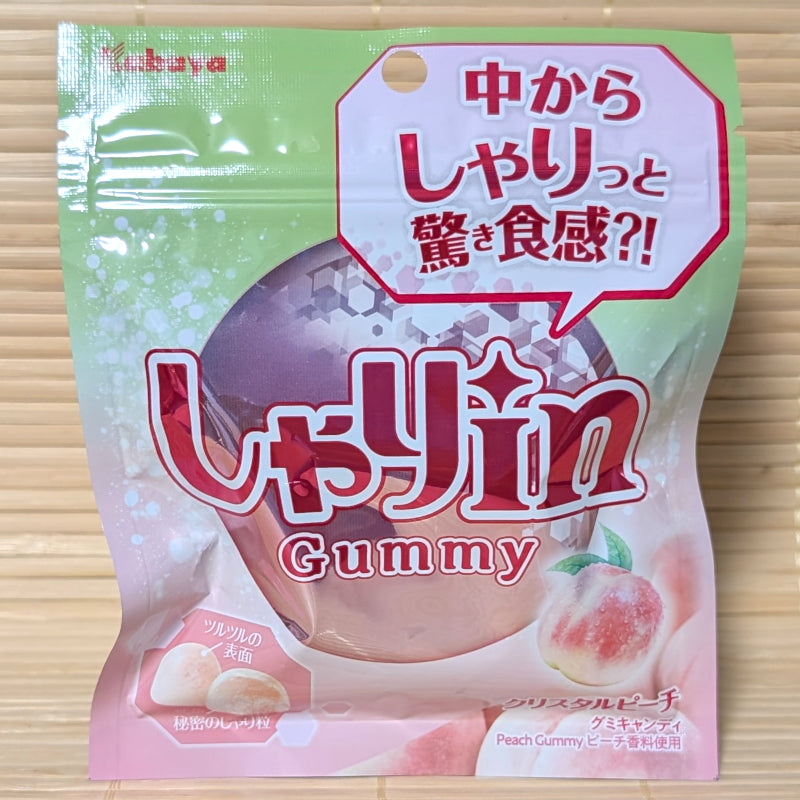 A light green and pink resealable pouch of Kabaya Shari-in gummies featuring a faceted peach and a cross-section of the crunchy center.