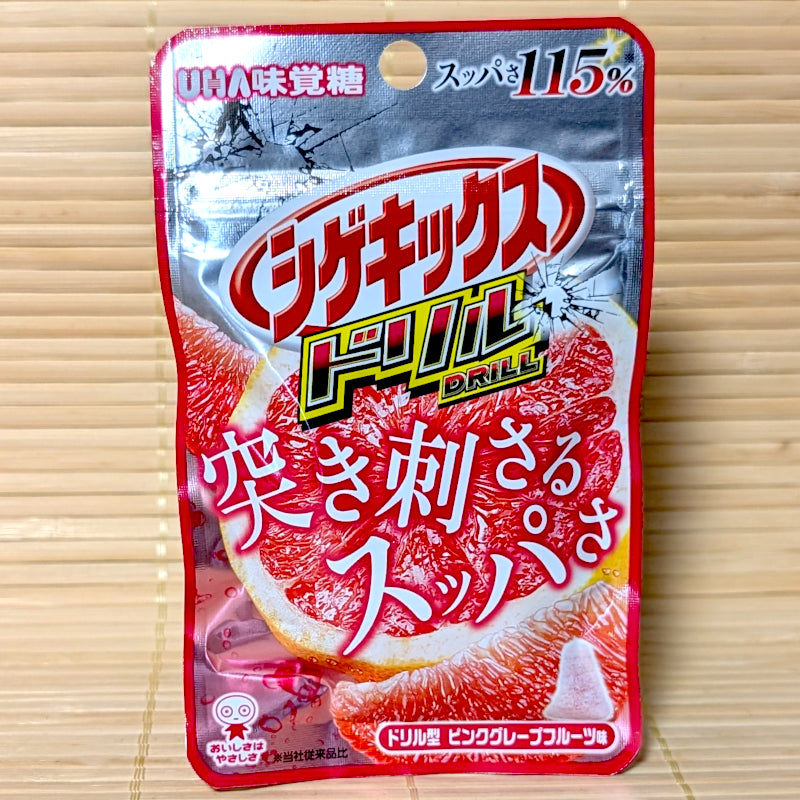 A metallic silver and red 23g pouch of Shigekix Drill Pink Grapefruit gummies featuring intense citrus graphics on a bamboo mat.
