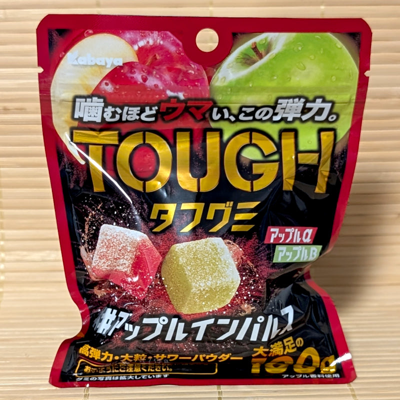 A 100g pouch of Kabaya TOUGH Gummy Apple Impulse showing red and green apple images with cube-shaped gummies on a bamboo mat.
