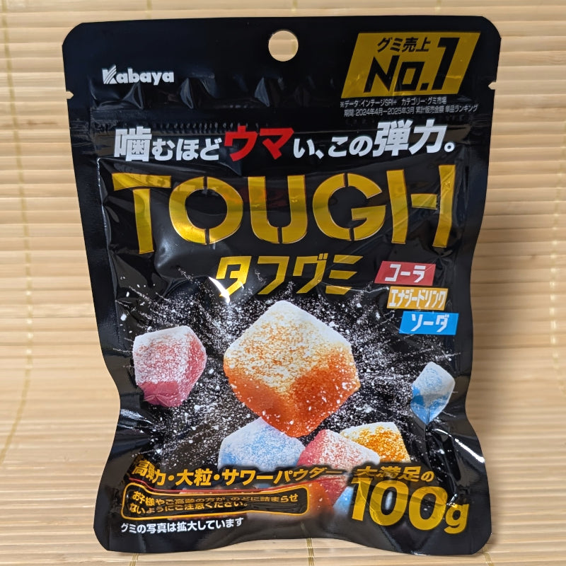 A black resealable pouch of Kabaya TOUGH Gummy on a tatami background featuring large, powder-coated colorful gummy cubes.