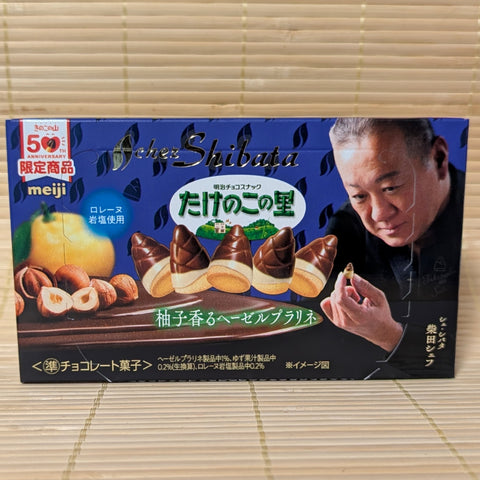A box of Meiji Takenoko no Sato Chez Shibata Hazelnut & Yuzu edition displayed on a traditional tatami background.