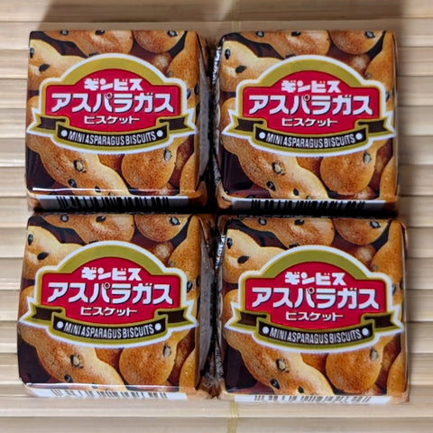 Four individually wrapped Tirol Chocolate cubes in the limited Ginbis Asparagus Biscuit flavor. Displayed on a tatami background.
