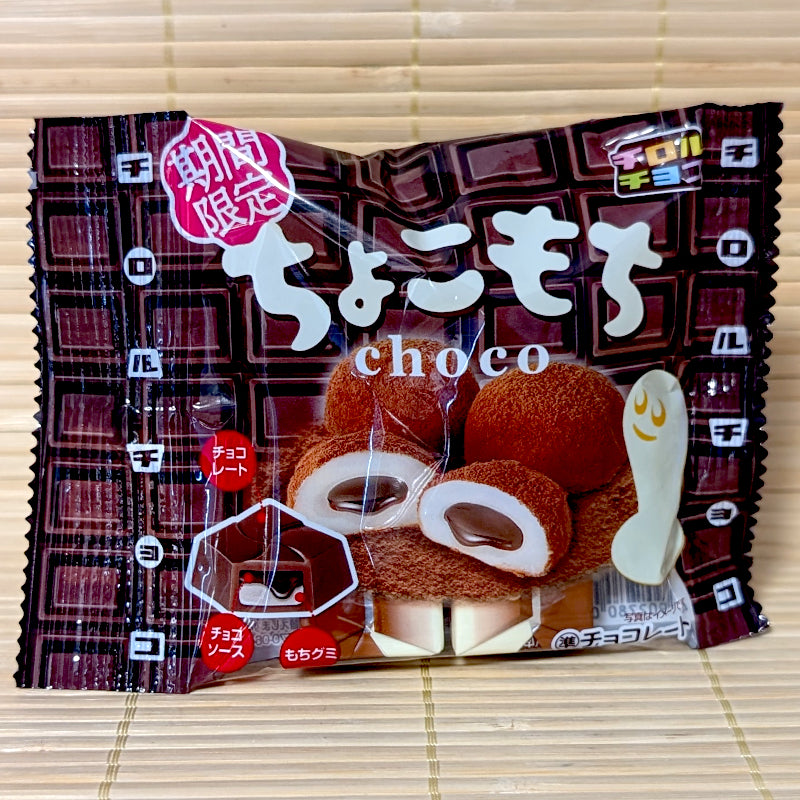 A black and brown 33g bag of Tirol Choco Mochi featuring chocolate-covered mochi cross-section graphics on a bamboo mat.