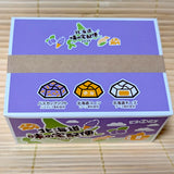 A top down close up of the purple Tirol Hokkaido 2026 gift box showing illustrations of Hascap Soft Cream, Hokkaido Corn, and Hokkaido Cheese chocolates.