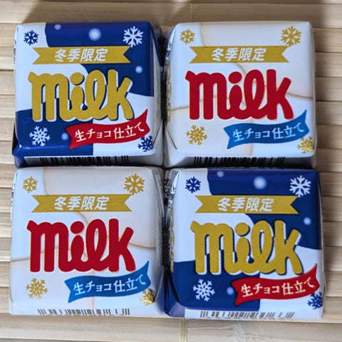 Four Tirol mini milk chocolate pieces in a winter white milk version. Displayed on a tatami surface.