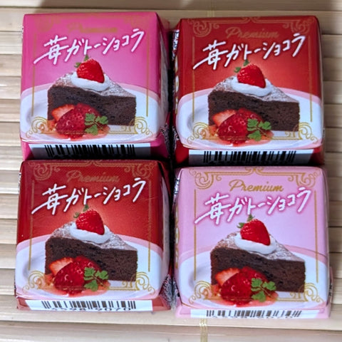 Four red and pink Tirol strawberry chocolate cake flavored morsels. Displayed on a tatami background.