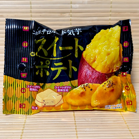 A black and yellow foil pouch of Tirol Choco Sweet Potato chocolates showing roasted sweet potato graphics and cross-section chocolate art on a bamboo mat background.