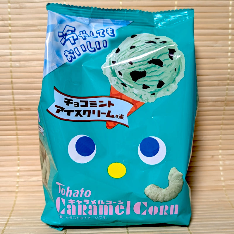 A mint-green 62g bag of Tohato Caramel Corn Chocolate Mint Ice Cream flavor showing a teal mascot and a scoop of chocomint ice cream on a tatami background.