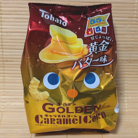 A metallic gold and red bag of Tohato Caramel Corn featuring a character face and an illustration of melting butter on a corn puff.