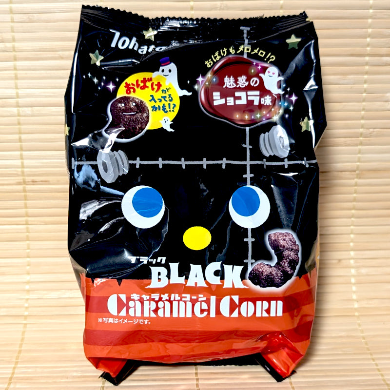 A black and orange Frankenstein-themed bag of Tohato Caramel Corn Halloween Black Chocolat on a bamboo mat background.
