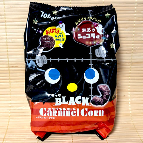 A black and orange Frankenstein-themed bag of Tohato Caramel Corn Halloween Black Chocolat on a bamboo mat background.