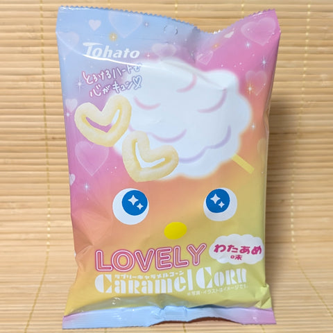 A pastel gradient Tohato Caramel Corn bag on a tatami background featuring heart-shaped snacks and a cotton candy cloud.