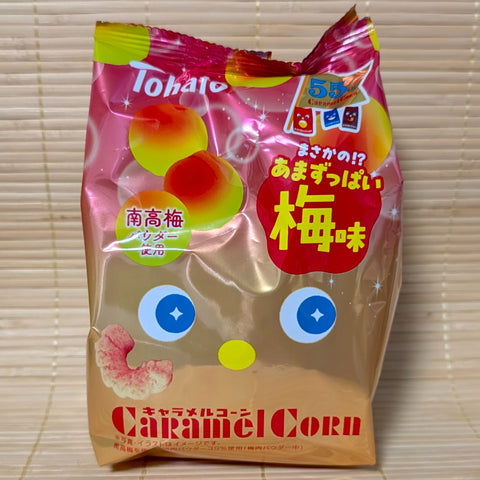 Limited Edition Tohato Caramel Corn Ume (Plum) flavor bag with 55th Anniversary logo. Displayed on a wooden background.