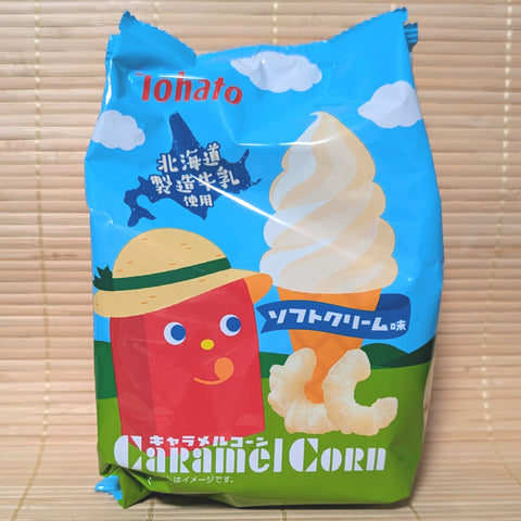 A blue and green 60g bag of Tohato Caramel Corn Soft Serve Ice Cream flavor showing the red mascot in a straw hat and a vanilla cone on a tatami background.
