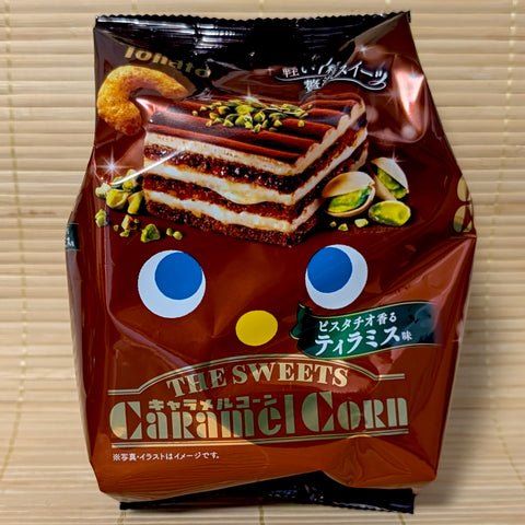 An elegant brown bag of Tohato Caramel Corn The SWEETS Pistachio Tiramisu featuring a picture of the dessert.
