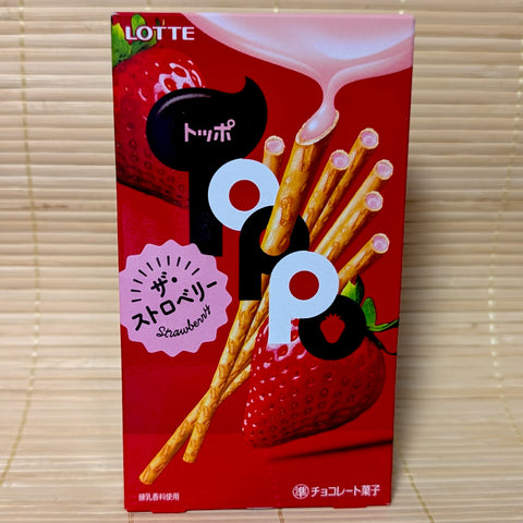 A bright red box of Lotte Toppo featuring strawberry-filled pretzel sticks and a large fresh strawberry. Displayed on a tatami background.