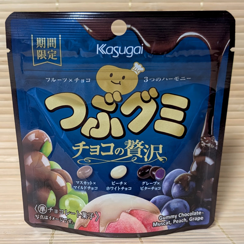 Dark blue bag of Kasugai Tsubugumi chocolate covered gummies featuring Muscat, Peach, and Grape.