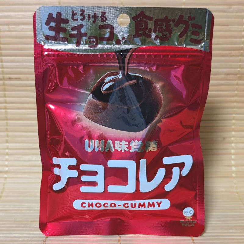 A metallic red pouch of UHA Chocorea Milk Chocolate gummies is displayed on a tatami background.