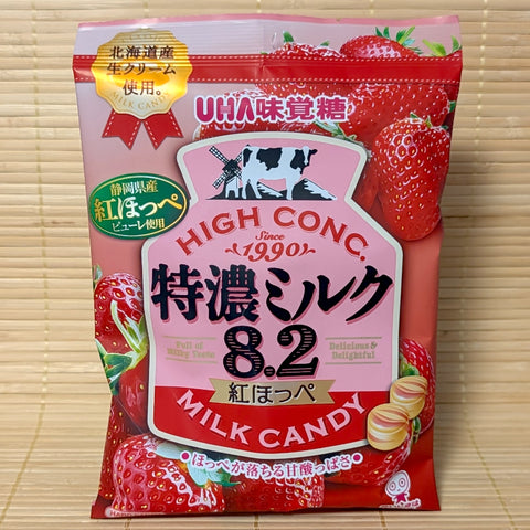 Pink 75g bag of UHA Tokunou Milk 8.2 Benihoppe Strawberry hard candies featuring fresh cream and ripe red strawberry graphics.