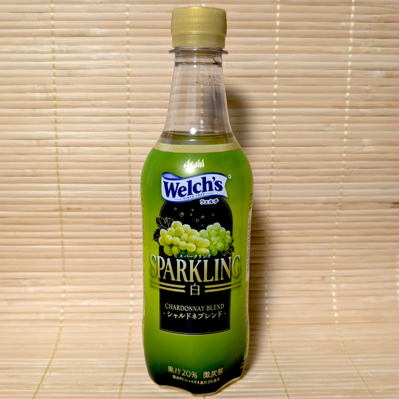 A sleek green 450ml bottle of Asahi Welch's Sparkling Chardonnay Blend white grape soda showing green grapes on a bamboo mat background.