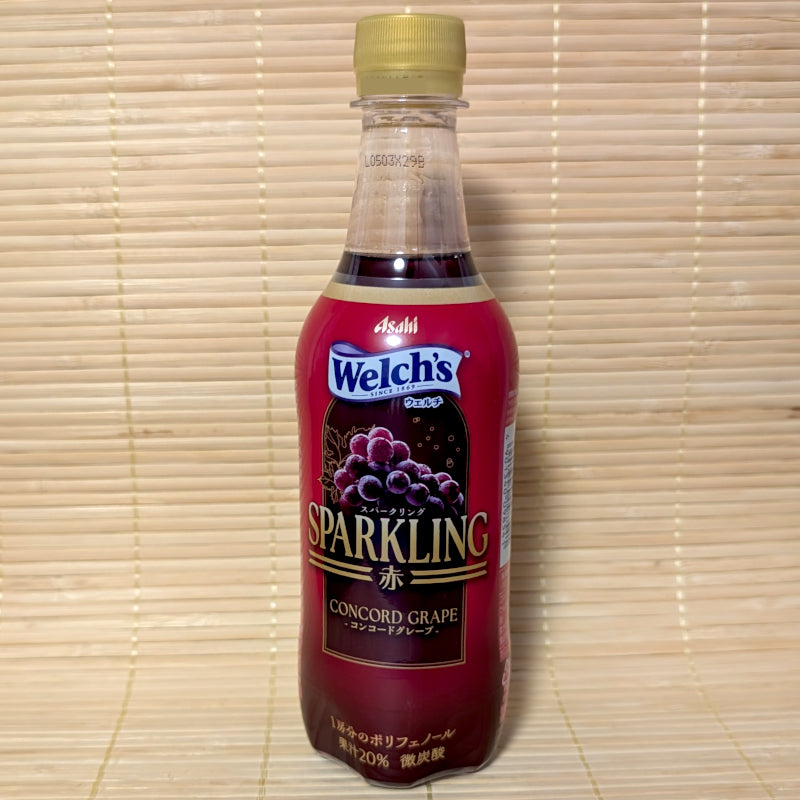 A sleek 450ml plastic bottle of Asahi Welch's Sparkling Concord Grape soda showing dark purple grape graphics on a tatami background.