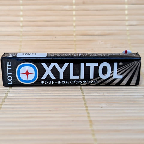 Pack of Lotte Xylitol Black Mint gum on a tatami surface