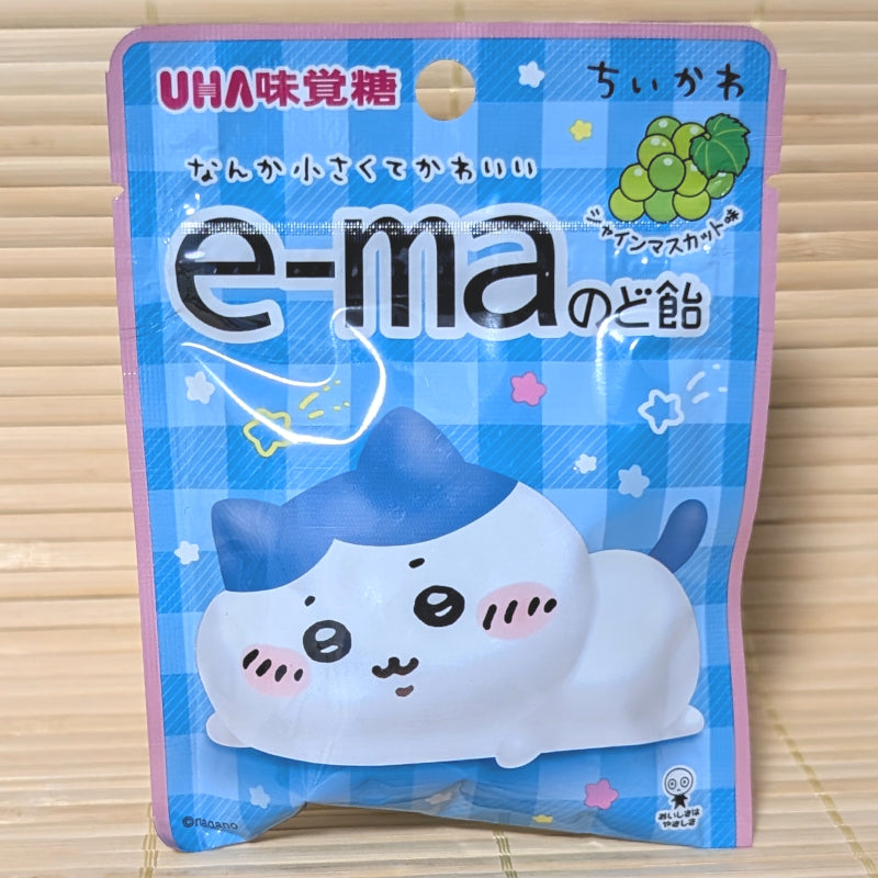 A blue checkered pouch of UHA e-ma Shine Muscat Grape candy featuring the character Hachiware from Chiikawa.